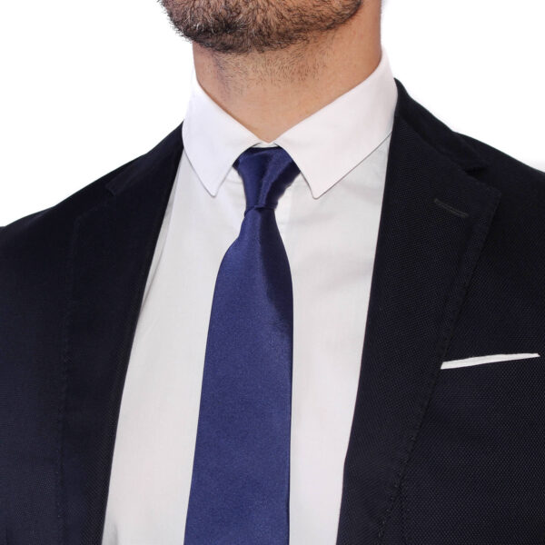 cravate homme bleu marine unie en soie sur costume